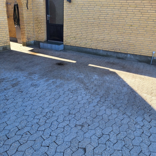 fliserensning ved gult hus