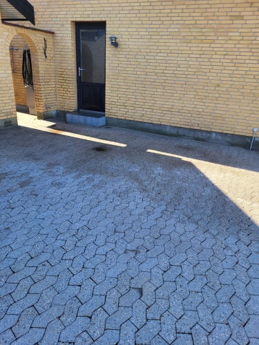 fliserensning ved gult hus