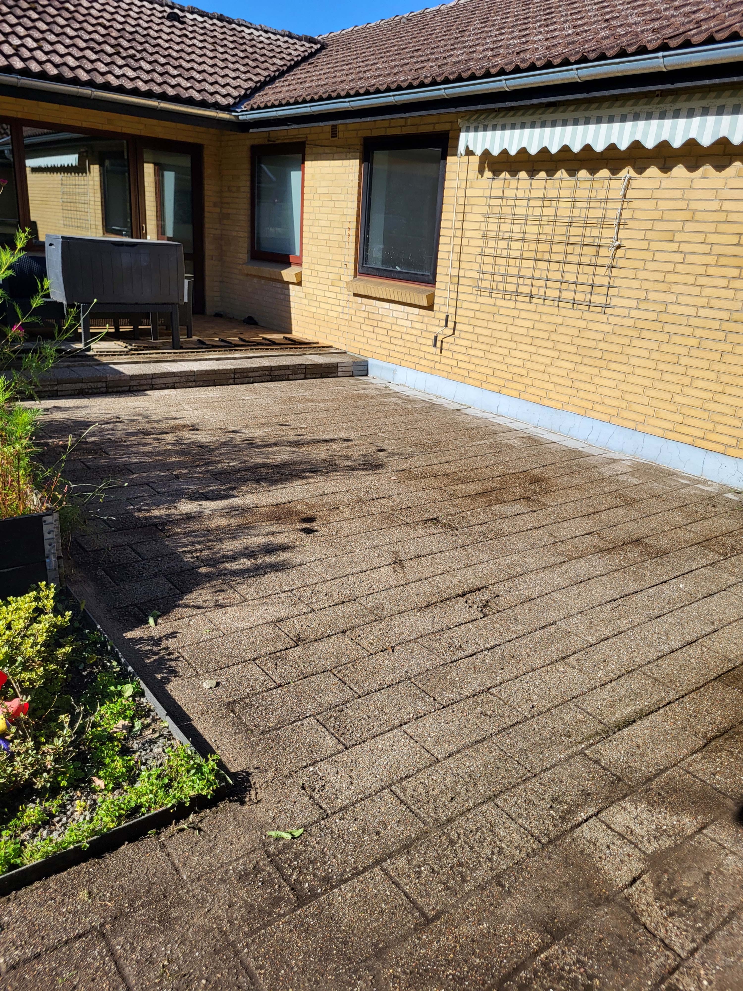 fliserensning af terrasse ved husmur